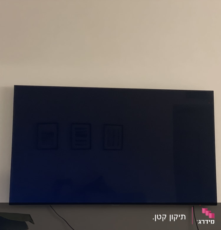 טלוויזיה תלויה על הקיר עם כבל חשמל